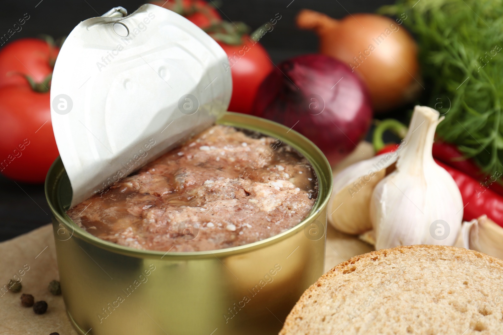 Photo of Canned meat in tin can and other products on table, closeup