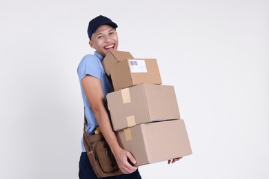 Photo of Happy postman with parcels on white background