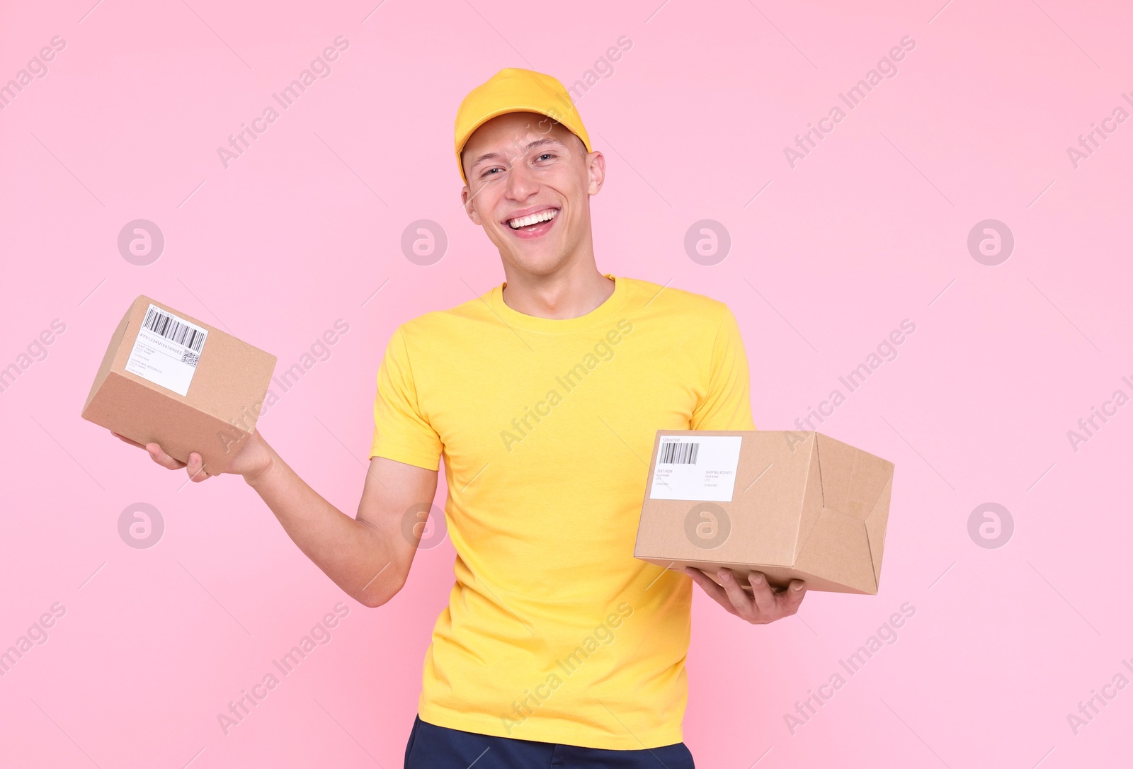 Photo of Happy postman with parcels on pink background. Space for text