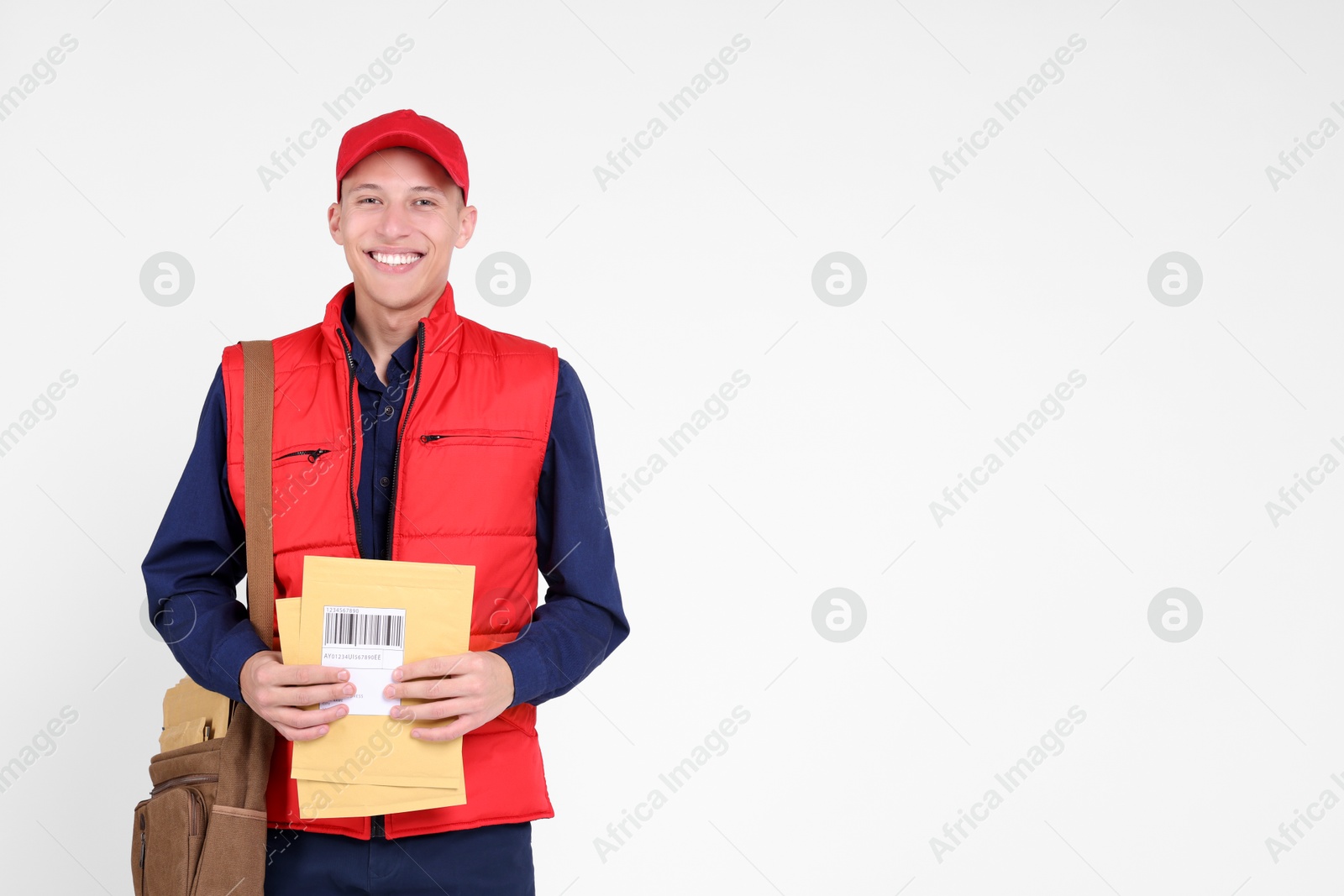 Photo of Happy postman with envelopes on white background. Space for text