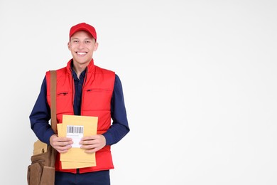 Photo of Happy postman with envelopes on white background. Space for text