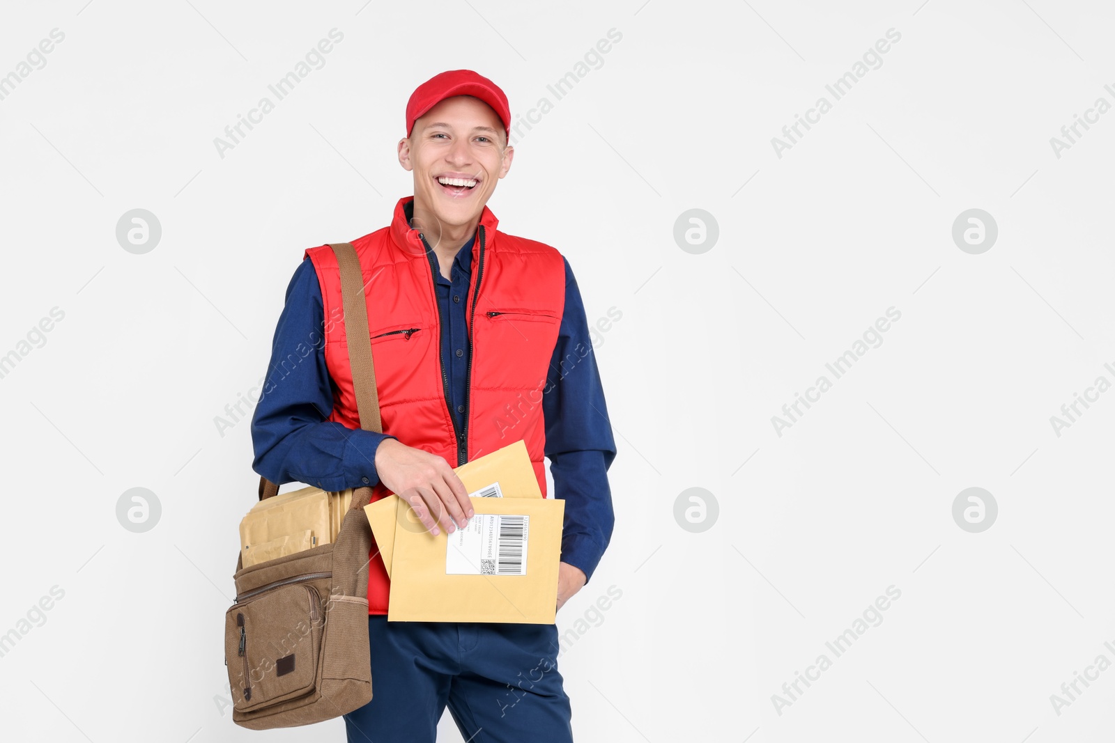 Photo of Happy postman with envelopes on white background. Space for text