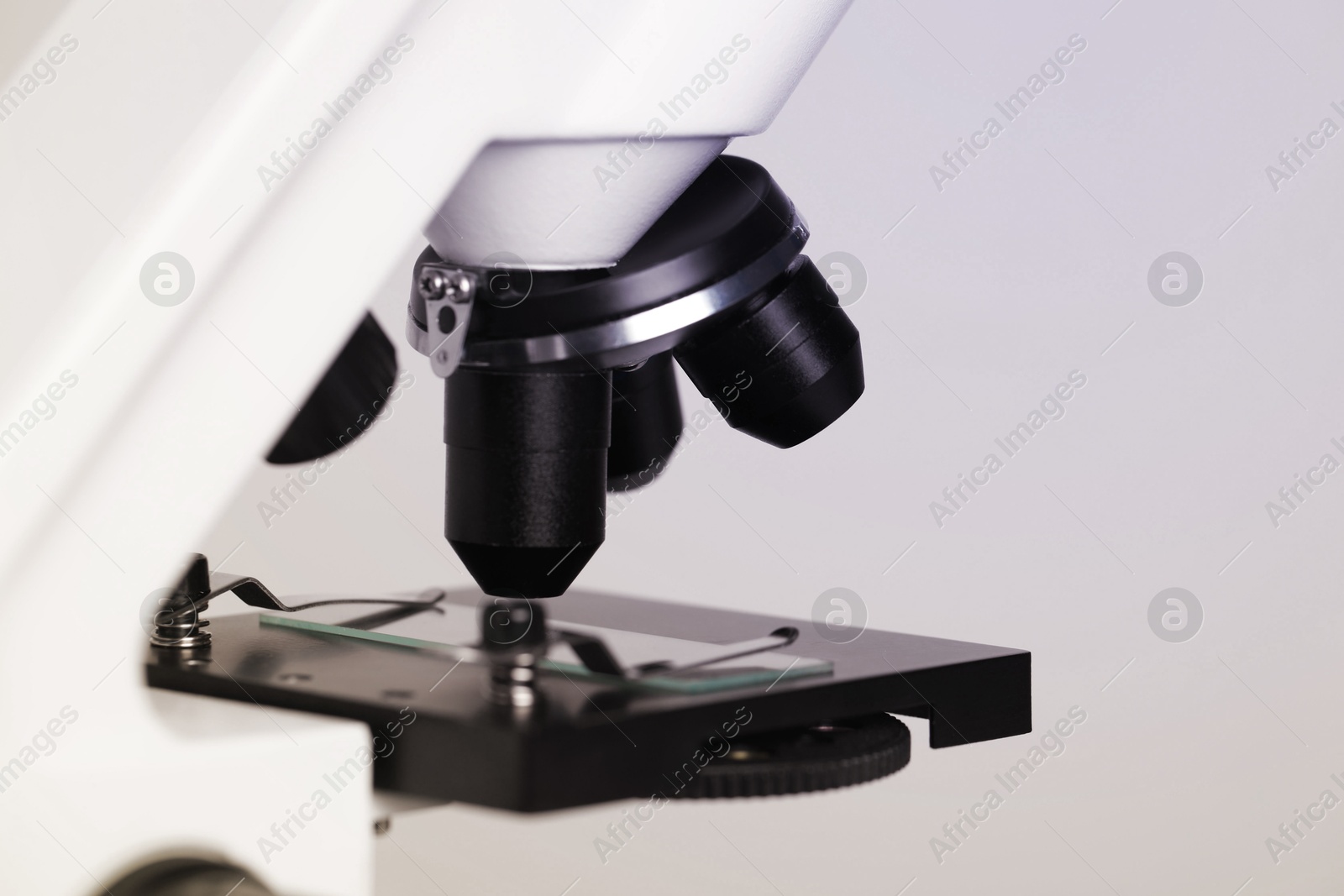 Photo of Science. Microscope with glass slide on light grey background, closeup