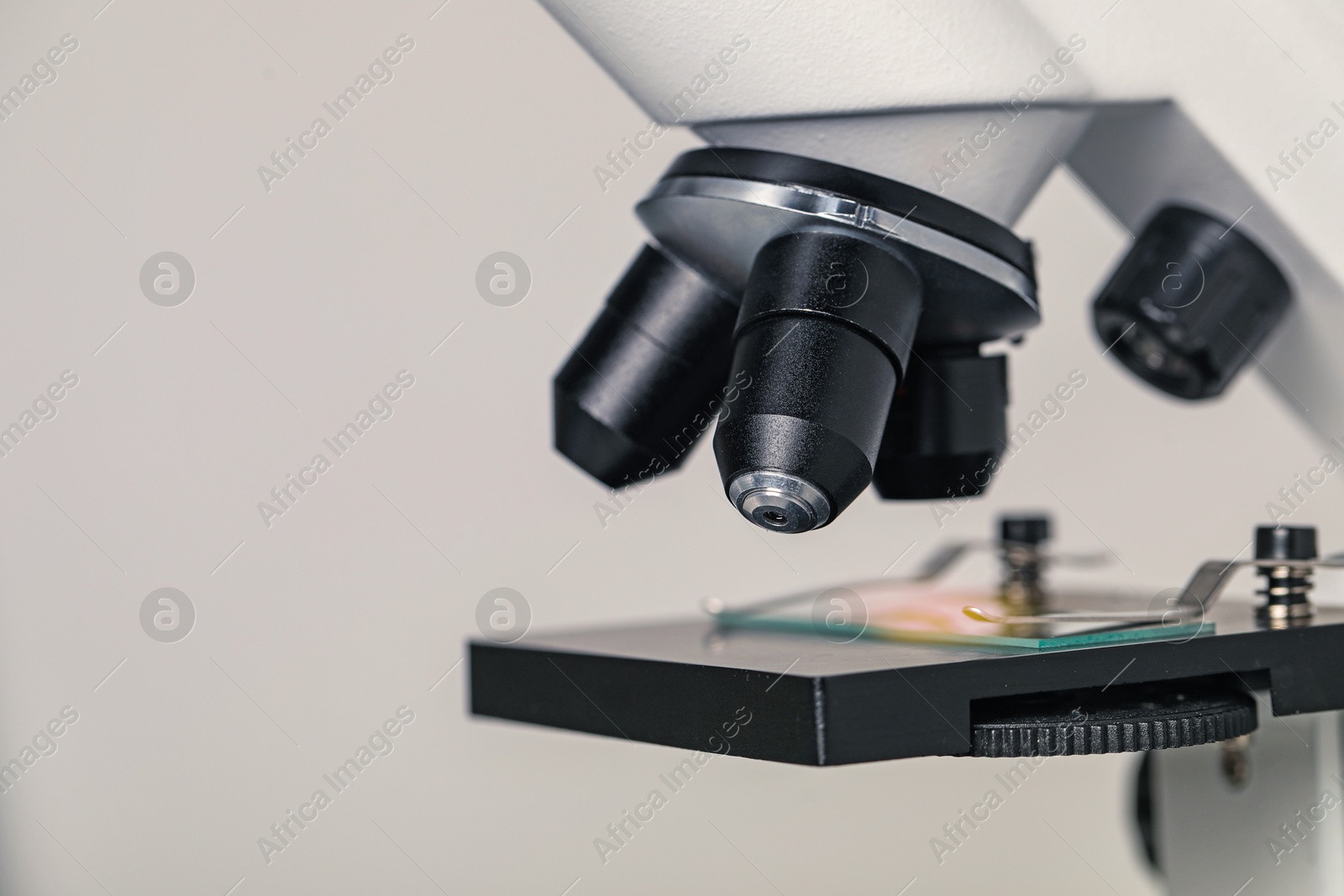 Photo of Science. Microscope with glass slide on light grey background, closeup. Space for text