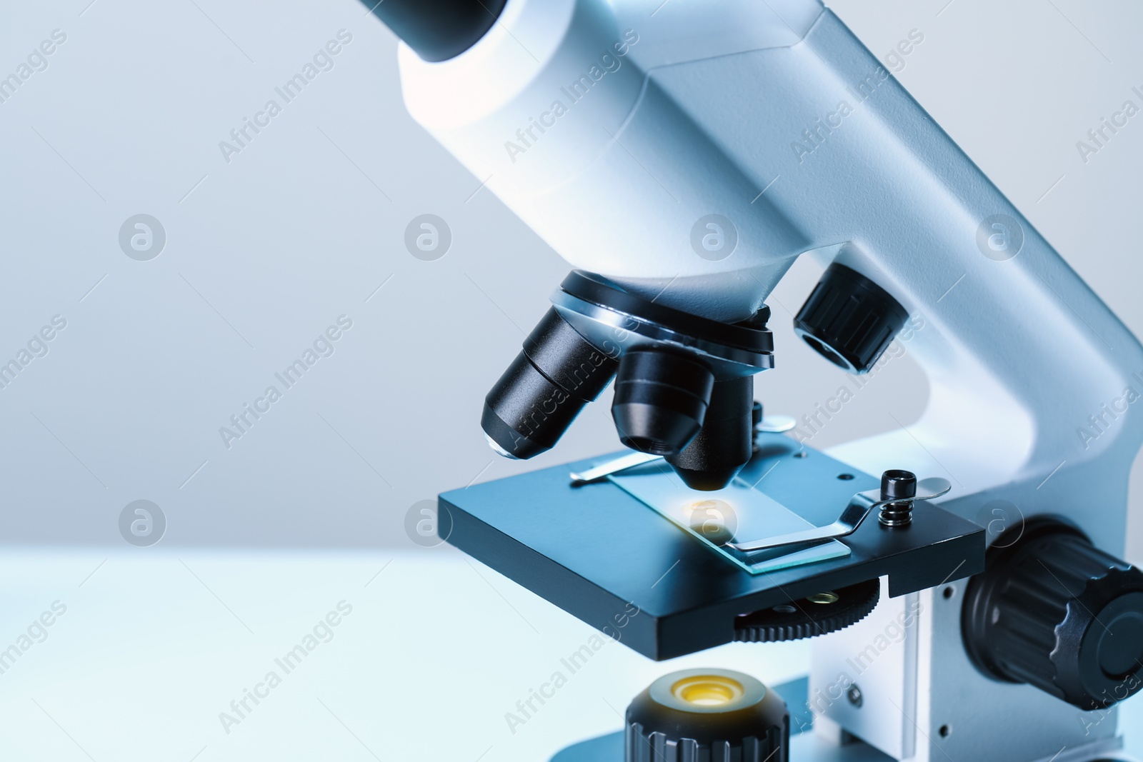 Photo of Science. Microscope with glass slide on blurred background, closeup. Space for text