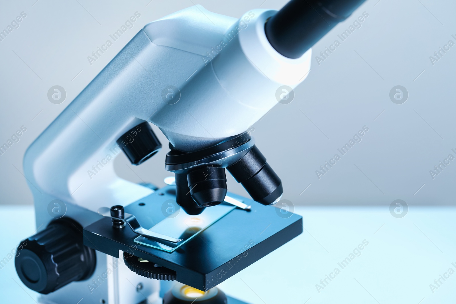 Photo of Science. Microscope with glass slide on blurred background, closeup. Space for text