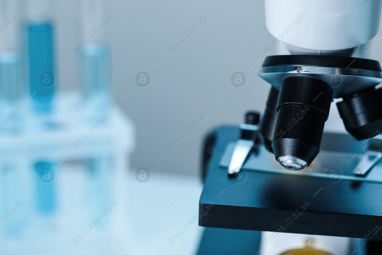 Photo of Science. Microscope with glass slide on blurred background, closeup. Space for text