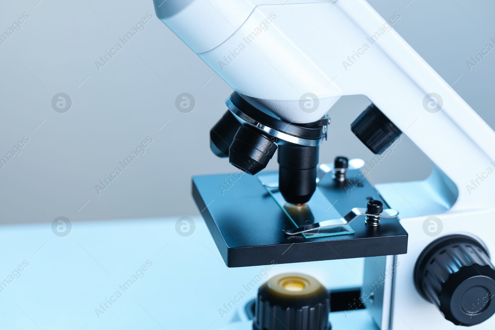 Photo of Science. Microscope with glass slide on blurred background, closeup. Space for text