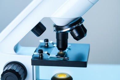 Photo of Science. Microscope with glass slide on blurred background, closeup