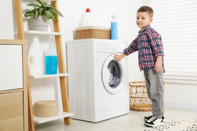 Little helper. Cute boy doing laundry at home