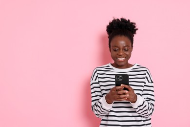 Photo of Happy woman with smartphone on pink background. Space for text