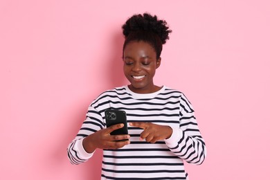 Photo of Happy woman with smartphone on pink background