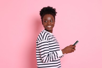 Photo of Happy woman with smartphone on pink background