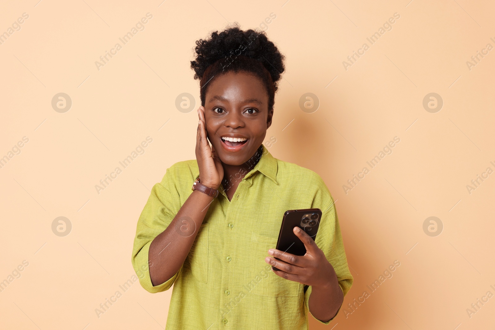 Photo of Happy woman with smartphone on beige background