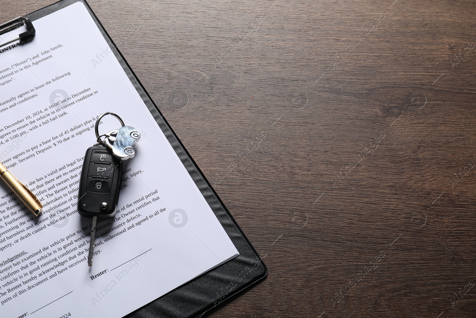 Photo of Car key and purchase agreement on wooden table, space for text. Buying auto