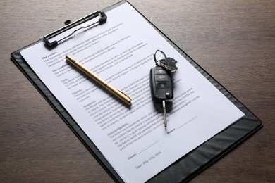 Car key and purchase agreement on wooden table. Buying auto