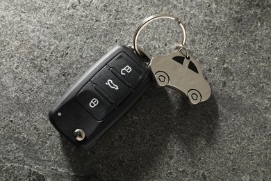 Photo of Car key with keychain on grey table, top view. Buying auto