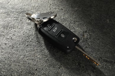 Car key with keychain on grey table, closeup. Buying auto