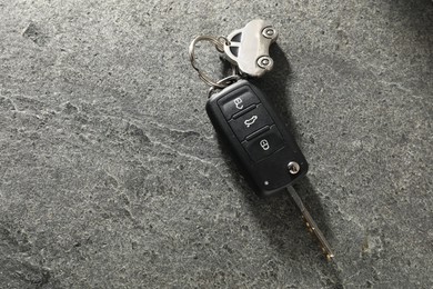 Photo of Car key with keychain on grey table, top view and space for text. Buying auto