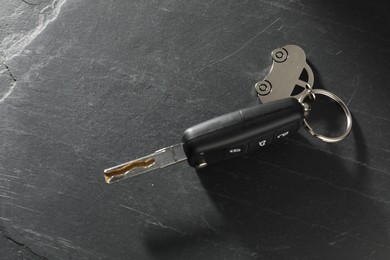 Photo of Car key with keychain on grey table, closeup. Buying auto