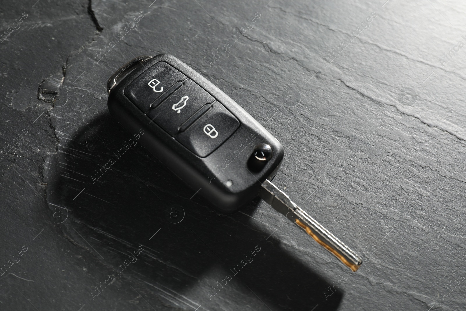 Photo of Car key on grey background, closeup. Buying auto