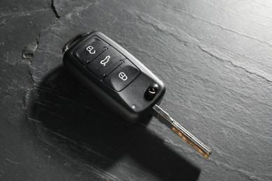 Car key on grey background, closeup. Buying auto