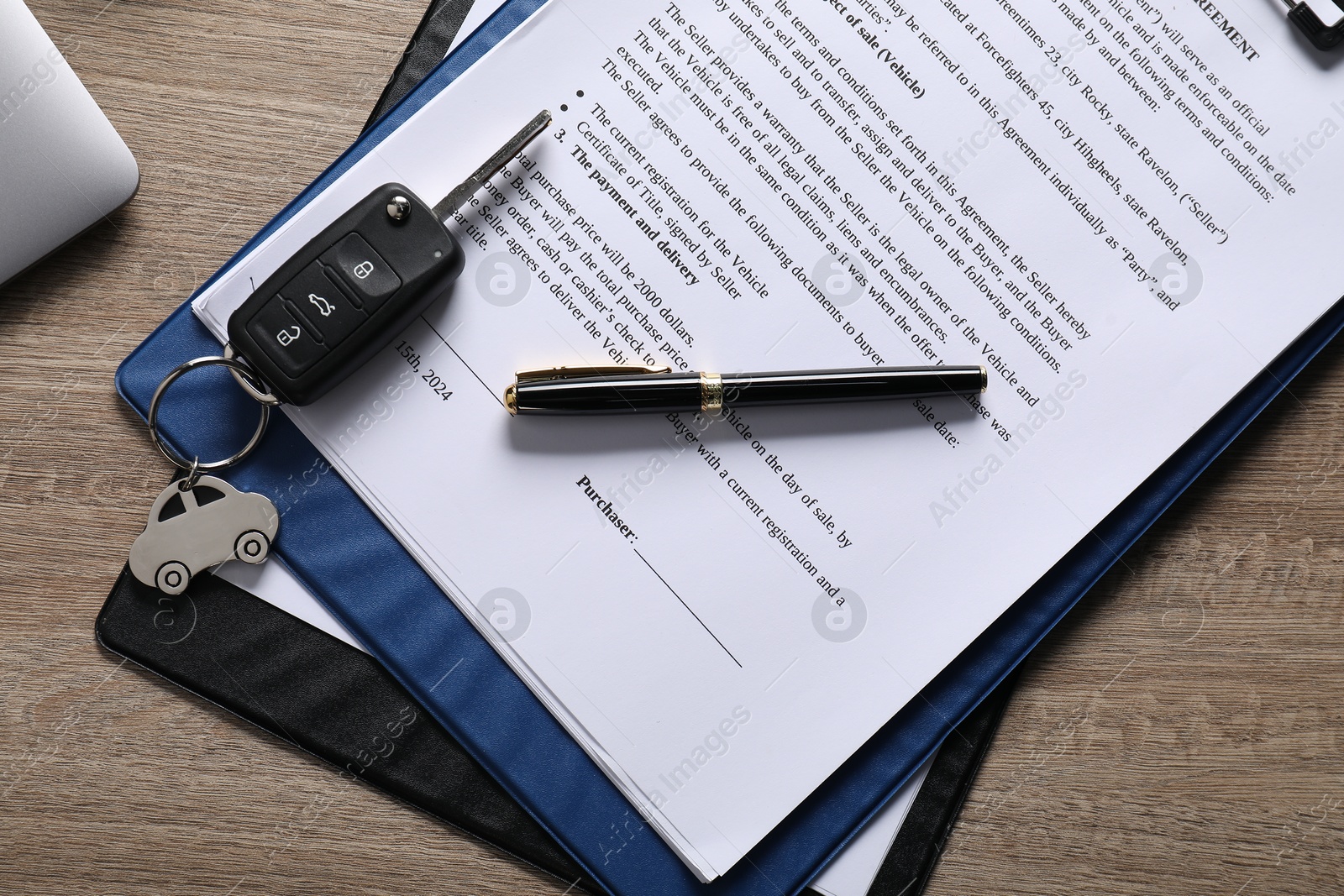 Photo of Car key, purchase agreement and laptop on wooden table, flat lay. Buying auto