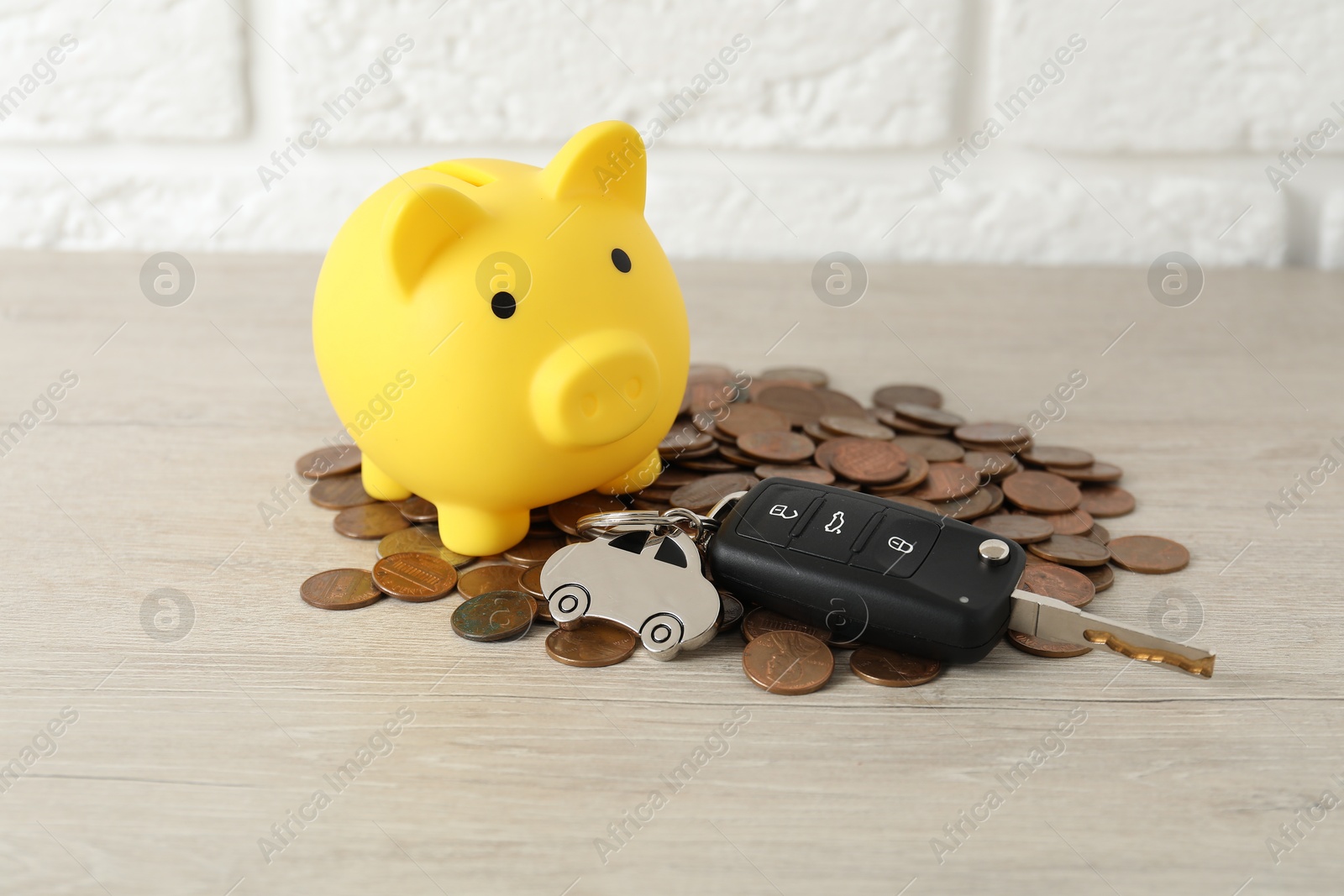 Photo of Car key, piggybank and coins on light background