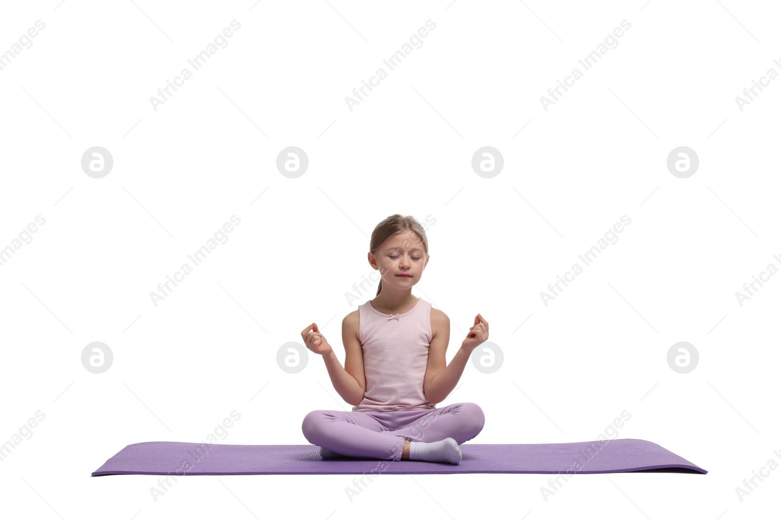 Photo of Little girl exercising on fitness mat against white background