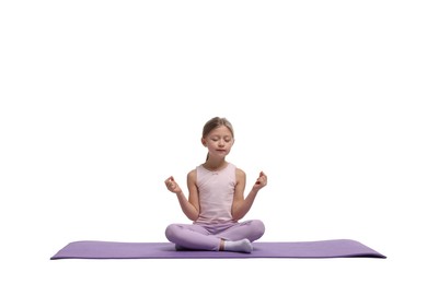 Photo of Little girl exercising on fitness mat against white background