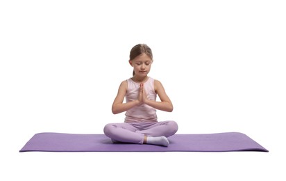 Little girl exercising on fitness mat against white background