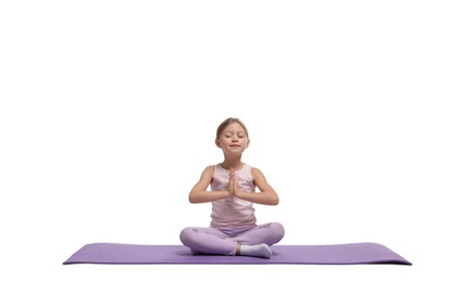 Little girl exercising on fitness mat against white background