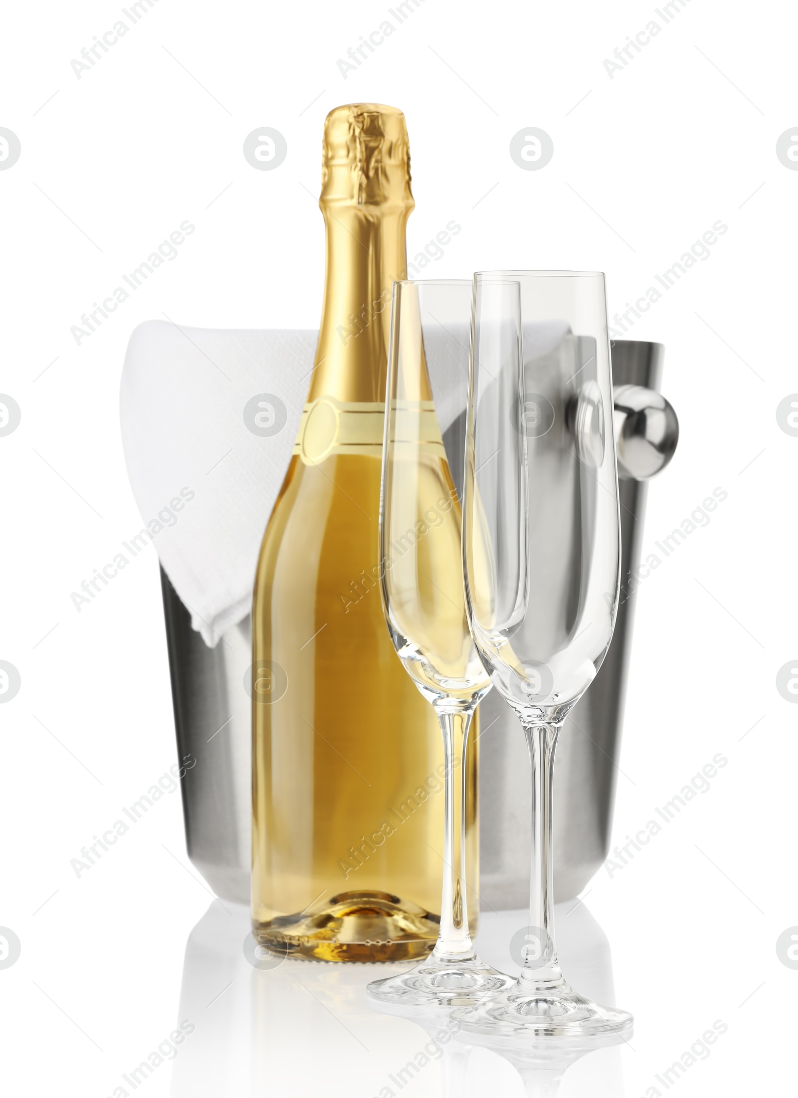 Photo of Bottle of champagne, ice bucket and empty glasses isolated on white