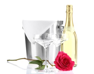 Photo of Bottle of champagne, glasses, beautiful rose and ice bucket isolated on white