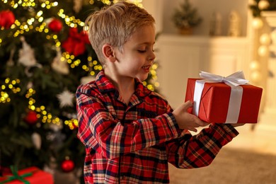 Photo of Little boy with Christmas box at home