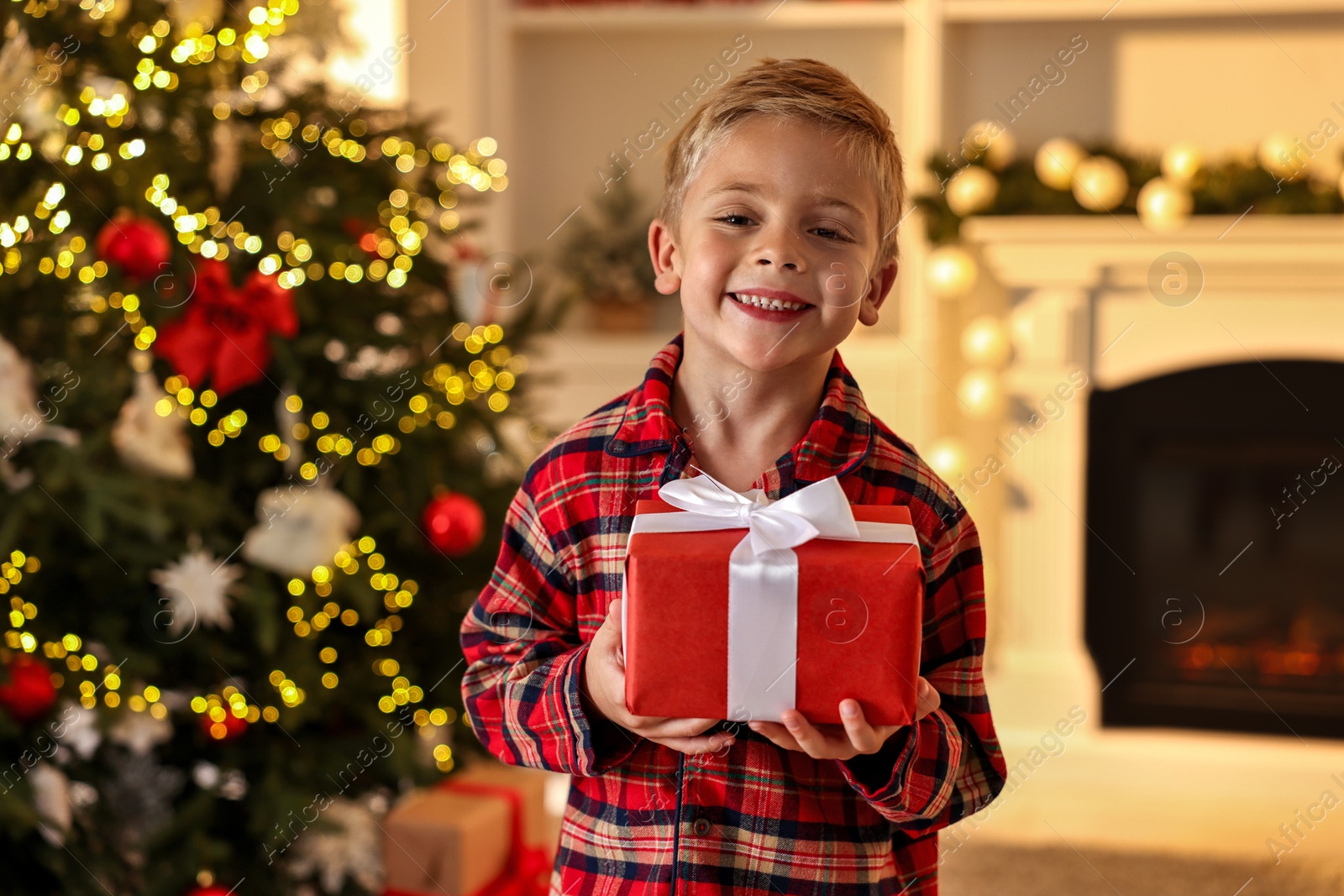 Photo of Little boy with Christmas box at home