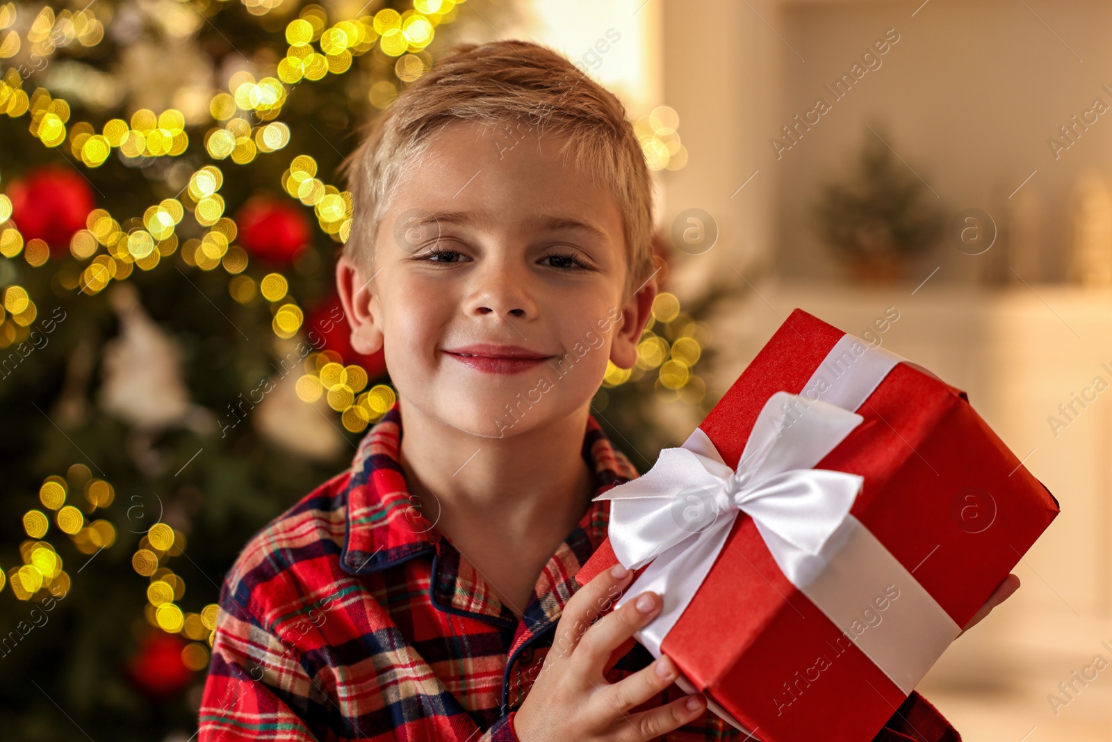 Photo of Little boy with Christmas box at home