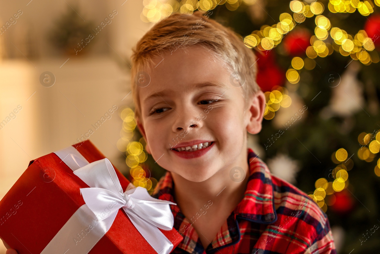 Photo of Little boy with Christmas box at home