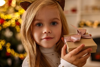 Little girl with Christmas gift at home