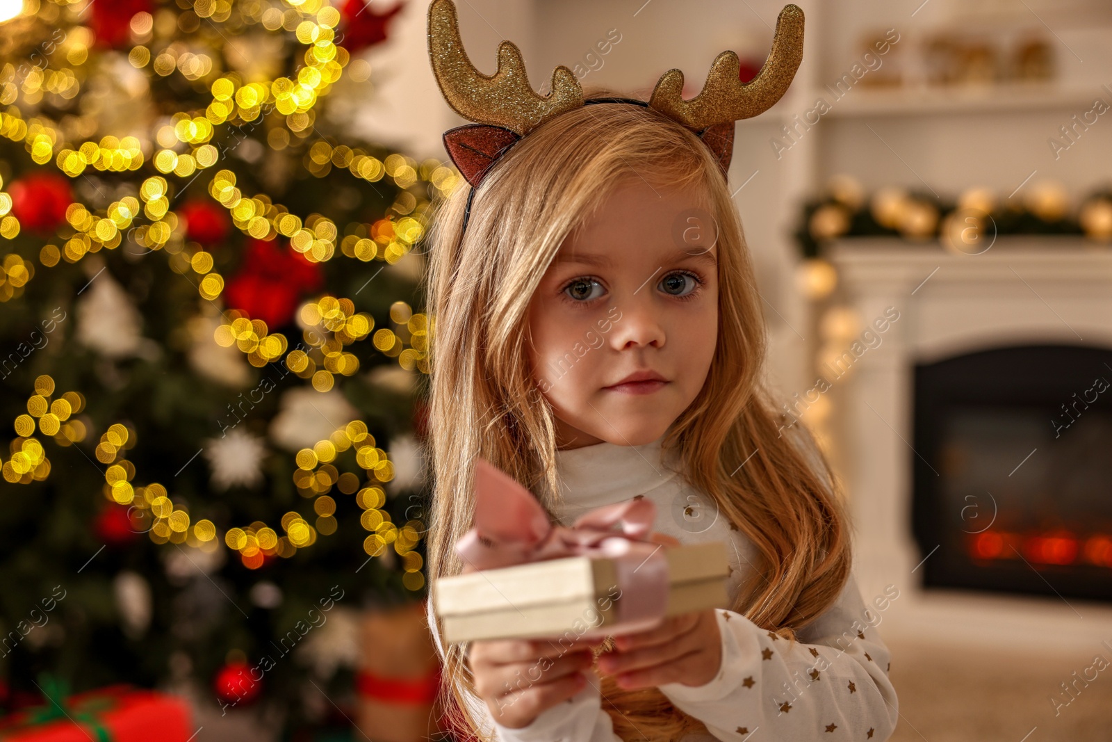 Photo of Little girl with Christmas gift at home