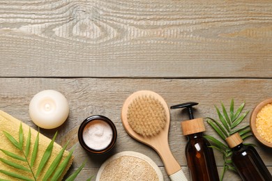 Photo of Spa composition with different cosmetic products and burning candle on wooden table, flat lay. Space for text