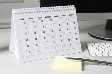 Photo of Timetable. Monthly planner, stationery and computer on white table