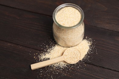 Photo of Oat bran in glass jar and spoon on wooden table