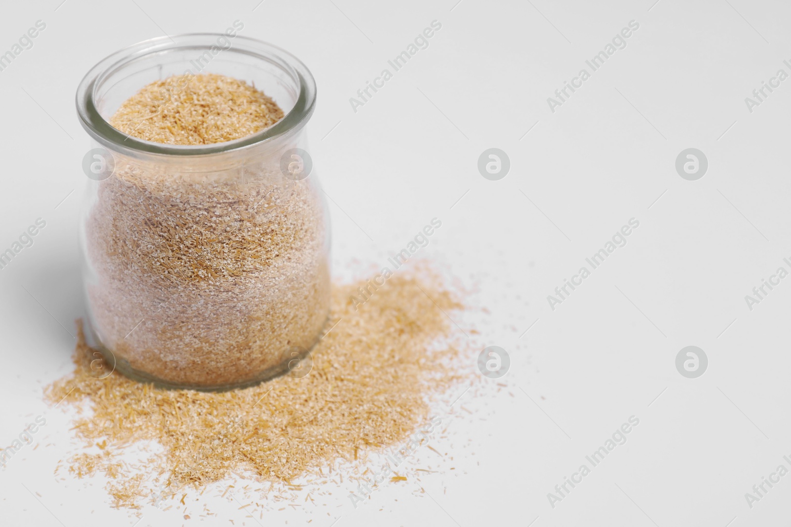 Photo of Oat bran in glass jar on white background