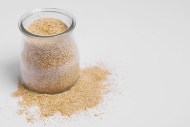 Photo of Oat bran in glass jar on white background