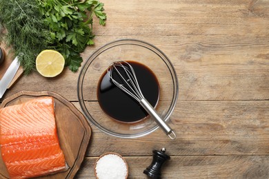 Photo of Salmon fillet, soy sauce and other products on wooden table, flat lay. Space for text