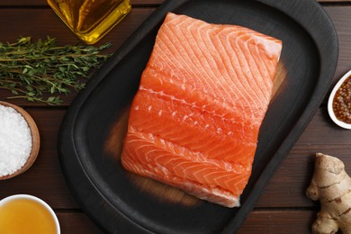 Photo of Salmon fillet, oil, spices and honey on wooden table, flat lay