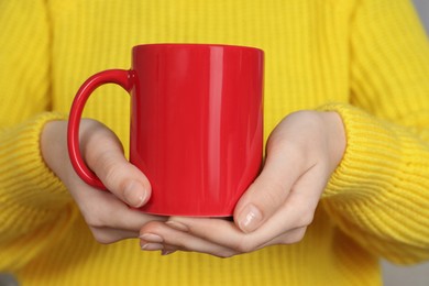 Photo of Woman with red ceramic cup, closeup. Mockup for design