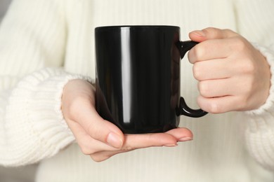 Photo of Woman with black ceramic cup, closeup. Mockup for design