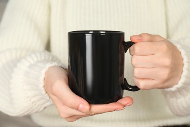 Photo of Woman with black ceramic cup, closeup. Mockup for design